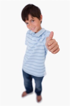 simsearch:6107-06117685,k - Portrait of a happy boy smiling at the camera with the thumb up against a white background Foto de stock - Super Valor sin royalties y Suscripción, Código: 400-05896315