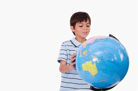 simsearch:400-04633938,k - Smiling boy looking at a globe against a white background Stock Photo - Budget Royalty-Free & Subscription, Code: 400-05896310