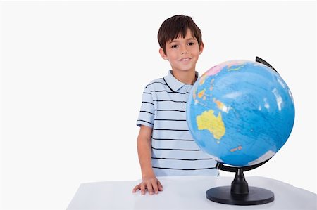 simsearch:400-04633938,k - Smiling boy posing with a globe against a white background Stock Photo - Budget Royalty-Free & Subscription, Code: 400-05896311