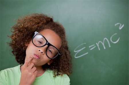 funny looking girls with glasses - Smart schoolgirl thinking in front of a blackboard Stock Photo - Budget Royalty-Free & Subscription, Code: 400-05896409