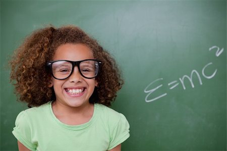 funny looking girls with glasses - Schoolgirl posing with the the mass-energy equivalence formula on a blackboard Stock Photo - Budget Royalty-Free & Subscription, Code: 400-05896402