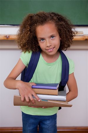 Portrait of a schoolgirl holding books in a classroom Stock Photo - Budget Royalty-Free & Subscription, Code: 400-05896416
