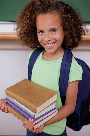 Portrait of a schoolgirl holding her books in a classroom Stock Photo - Budget Royalty-Free & Subscription, Code: 400-05896418