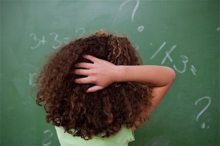 simsearch:400-05896550,k - Schoolgirl thinking about algebra while scratching the back of her head in front of a blackboard Stock Photo - Budget Royalty-Free & Subscription, Code: 400-05896484