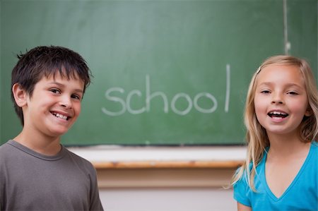 Happy pupils posing together in front of a chalkboard Stock Photo - Budget Royalty-Free & Subscription, Code: 400-05896515