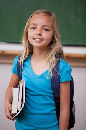 Portrait of a blonde schoolgirl holding her books in a classroom Stock Photo - Budget Royalty-Free & Subscription, Code: 400-05896512