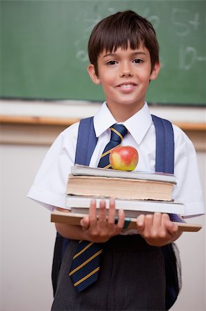 school food bag - Portrait of a schoolboy holding books and an apple in a classroom Stock Photo - Budget Royalty-Free & Subscription, Code: 400-05896544