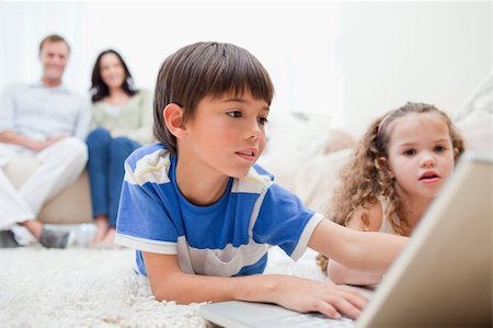 simsearch:400-05897773,k - Young kids playing computer games on the carpet with parents behind them Stock Photo - Budget Royalty-Free & Subscription, Code: 400-05896572