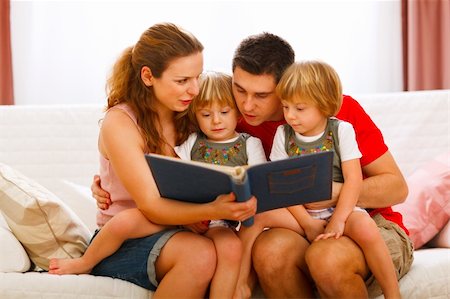 family photos in album - Mother and father looking photo album with twins daughters Stock Photo - Budget Royalty-Free & Subscription, Code: 400-05896820