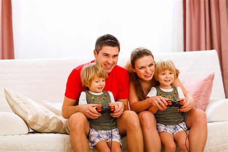 dad with toddler playing game - Mother and father playing with twins daughter on console Stock Photo - Budget Royalty-Free & Subscription, Code: 400-05896821