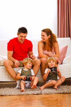 dad with toddler playing game - Twins daughters playing on console at home Stock Photo - Budget Royalty-Free & Subscription, Code: 400-05896823
