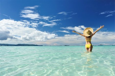 Girl on a tropical beach with outstretched arms Foto de stock - Royalty-Free Super Valor e Assinatura, Número: 400-05897544