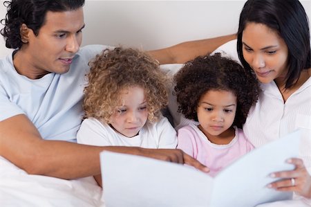 simsearch:400-05751566,k - Parents reading a story for their young children Stock Photo - Budget Royalty-Free & Subscription, Code: 400-05897685