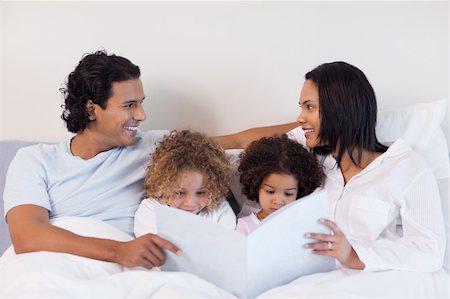simsearch:400-05751566,k - Young family reading a story in the bedroom Stock Photo - Budget Royalty-Free & Subscription, Code: 400-05897687