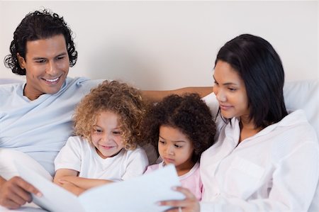 simsearch:400-05751566,k - Happy young family enjoys reading a story together Stock Photo - Budget Royalty-Free & Subscription, Code: 400-05897688