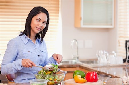 simsearch:400-05751129,k - Young woman stirring her salad in the kitchen Stockbilder - Microstock & Abonnement, Bildnummer: 400-05897760
