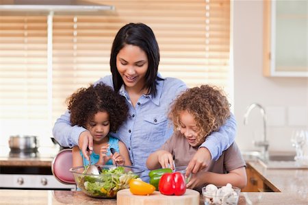 Young mother and daughters preparing salad in the kitchen together Stock Photo - Budget Royalty-Free & Subscription, Code: 400-05897763