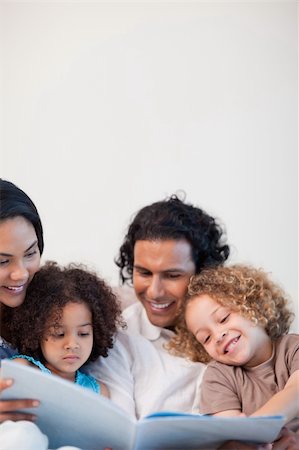 simsearch:400-05897773,k - Cheerful young family on the sofa looking at photo album together Stock Photo - Budget Royalty-Free & Subscription, Code: 400-05897783