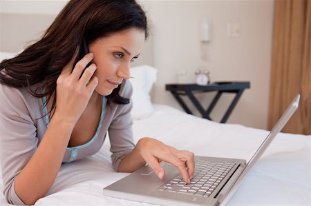 simsearch:400-05737165,k - Young woman on the phone using laptop Stock Photo - Budget Royalty-Free & Subscription, Code: 400-05897947