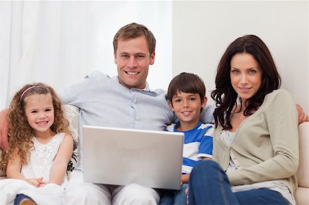 simsearch:400-05897773,k - Young family surfing the internet in the living room together Stock Photo - Budget Royalty-Free & Subscription, Code: 400-05898113