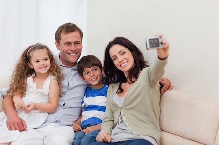 simsearch:400-05897773,k - Young mother taking family photograph on the couch Stock Photo - Budget Royalty-Free & Subscription, Code: 400-05898162
