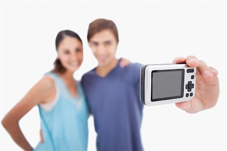 simsearch:400-04151970,k - Couple taking a photo of themselves against a white background Fotografie stock - Microstock e Abbonamento, Codice: 400-05898175