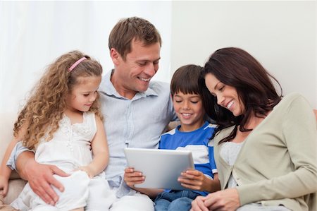 simsearch:400-05897773,k - Young family using tablet on the sofa Stock Photo - Budget Royalty-Free & Subscription, Code: 400-05898170