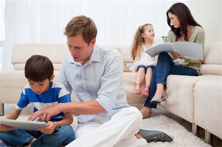 simsearch:400-05897773,k - Young family spending spare time in the living room Stock Photo - Budget Royalty-Free & Subscription, Code: 400-05898171