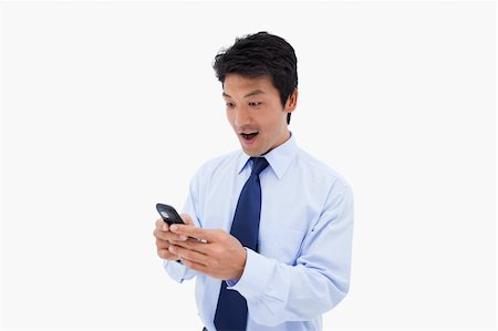 Surprised business man reading a text message against a white background Photographie de stock - Aubaine LD & Abonnement, Code: 400-05898319