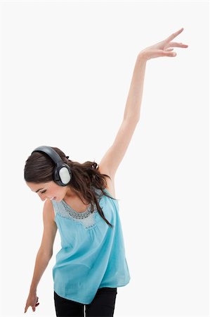 simsearch:400-05717354,k - Portrait of a delighted woman dancing while listening to music against a white background Stock Photo - Budget Royalty-Free & Subscription, Code: 400-05898335