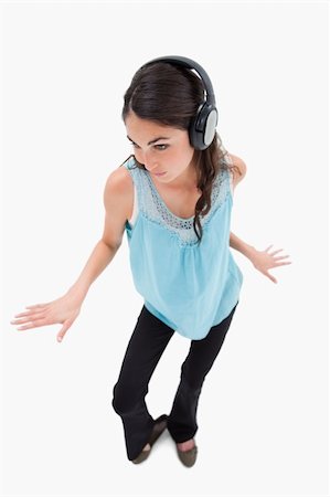 simsearch:400-05717354,k - Portrait of a happy woman dancing while listening to music against a white background Stock Photo - Budget Royalty-Free & Subscription, Code: 400-05898344