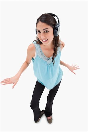 simsearch:400-05717354,k - Portrait of a cheerful woman dancing while listening to music against a white background Stock Photo - Budget Royalty-Free & Subscription, Code: 400-05898345