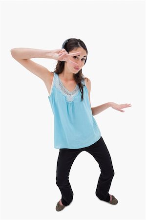 simsearch:400-05717354,k - Portrait of a playful woman dancing while listening to music against a white background Stock Photo - Budget Royalty-Free & Subscription, Code: 400-05898348