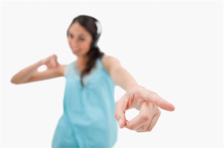 simsearch:400-05717354,k - Cheerful woman dancing while listening to music against a white background Stock Photo - Budget Royalty-Free & Subscription, Code: 400-05898342