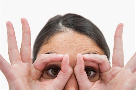 simsearch:400-05895521,k - Close up of a woman with her fingers around her eyes against a white background Stock Photo - Budget Royalty-Free & Subscription, Code: 400-05898432