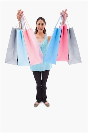 simsearch:400-06092781,k - Portrait of a woman showing shopping bags against a white background Photographie de stock - Aubaine LD & Abonnement, Code: 400-05898445