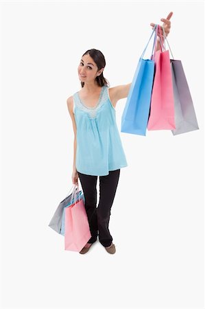 simsearch:400-06092781,k - Portrait of a happy woman showing shopping bags against a white backgorund Photographie de stock - Aubaine LD & Abonnement, Code: 400-05898446