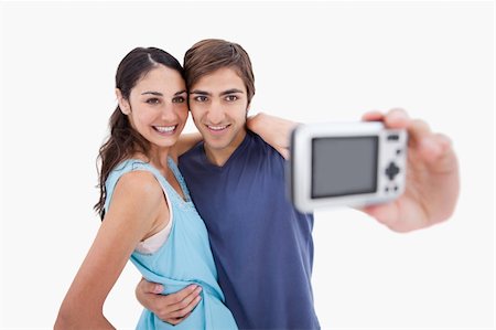 simsearch:400-04151970,k - Young couple taking a picture of themselves against a white background Fotografie stock - Microstock e Abbonamento, Codice: 400-05898455