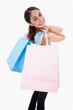 simsearch:400-06092781,k - Portrait of a smiling woman posing with shopping bags against a white background Photographie de stock - Aubaine LD & Abonnement, Code: 400-05898451