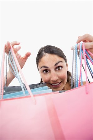 simsearch:400-06092781,k - Portrait of a cheerful woman showing shopping bags against white background Photographie de stock - Aubaine LD & Abonnement, Code: 400-05898453