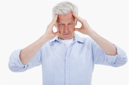 simsearch:400-04978521,k - Exhausted man having a headache against a white background Stock Photo - Budget Royalty-Free & Subscription, Code: 400-05898515