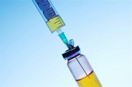 Syringe and vial on a blue background. Stockbilder - Microstock & Abonnement, Bildnummer: 400-05899030