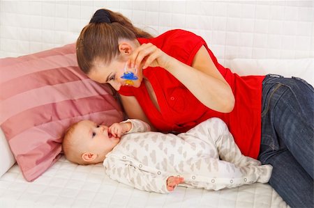 simsearch:400-06086432,k - Young mother laying on sofa and playing with baby Stockbilder - Microstock & Abonnement, Bildnummer: 400-05899074