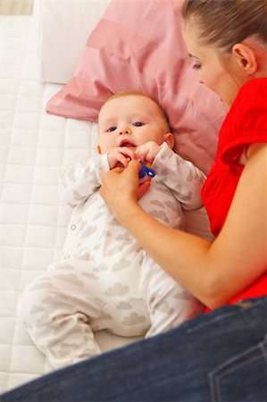 simsearch:400-06067090,k - Baby playing with mother on sofa Stockbilder - Microstock & Abonnement, Bildnummer: 400-05899075