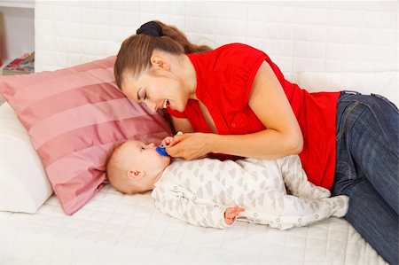 simsearch:400-06067090,k - Happy mother laying on couch and giving soother to baby Stockbilder - Microstock & Abonnement, Bildnummer: 400-05899073