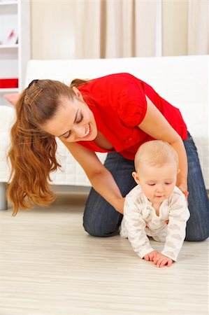 simsearch:400-06086432,k - Mother helping cheerful baby learn to creep Stockbilder - Microstock & Abonnement, Bildnummer: 400-05899085