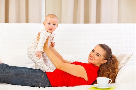 simsearch:400-05692875,k - Smiling mother and adorable baby playing on couch Foto de stock - Super Valor sin royalties y Suscripción, Código: 400-05899095