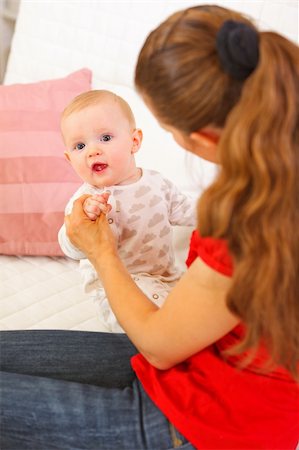 simsearch:400-06067090,k - Interested baby playing with mothers on couch Stockbilder - Microstock & Abonnement, Bildnummer: 400-05899093