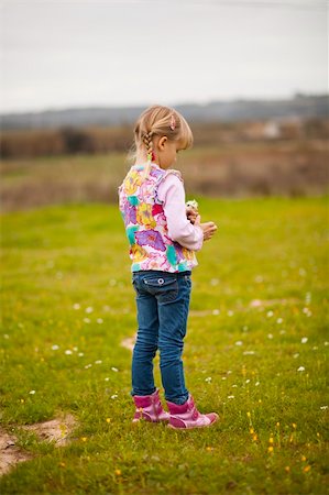 simsearch:400-06768635,k - Cute little girl standing on a green field with flowers Foto de stock - Royalty-Free Super Valor e Assinatura, Número: 400-05890704