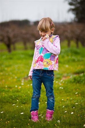 simsearch:400-06768635,k - Cute little girl standing on a green field with flowers Foto de stock - Royalty-Free Super Valor e Assinatura, Número: 400-05890705